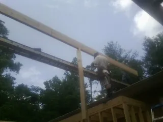 Carpenter setting a ridge beam over a new addition frame — Ice Dam Removal by Roofing Brothers in Lavina