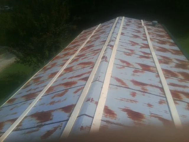 Rusted metal roof panels with new wood purlins before replacement — Storm Damage Roof Repair in Lavina by Roofing Brothers